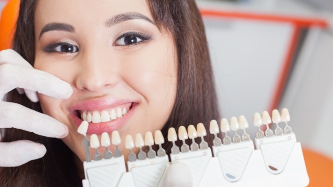 Smiling woman getting dental veneers from cosmetic dentist in Irving