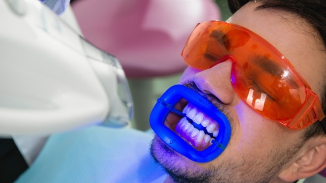Man getting professional teeth whitening in dental office