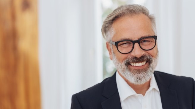 Smiling older man with glasses and business attire