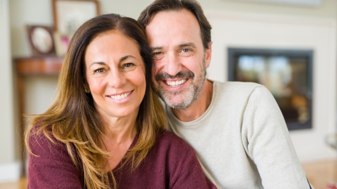 Husband and wife smiling in their living room