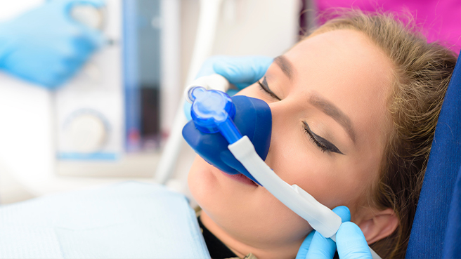 Young woman wearing nose mask for nitrous oxide sedation dentistry in Irving