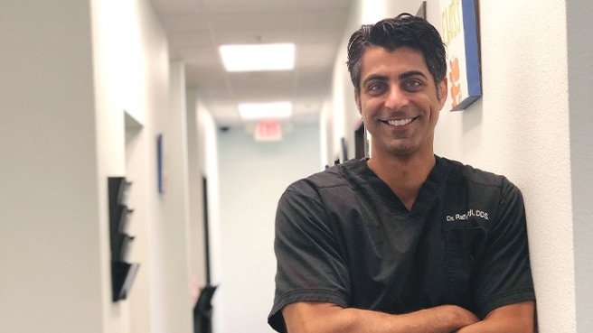 Doctor Rafiq smiling in hallway of dental office