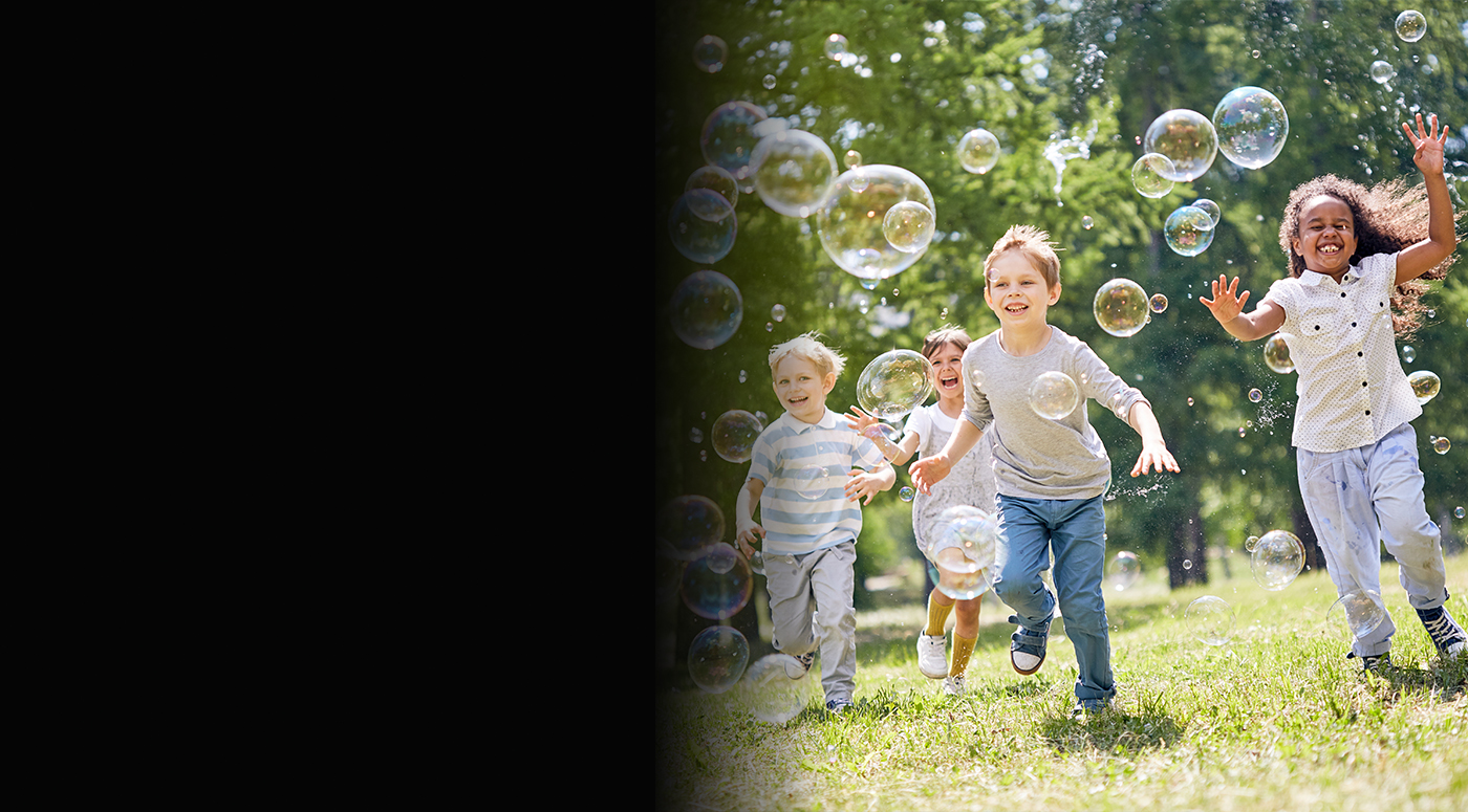 Children playing outside and blowing bubbles