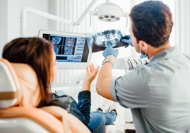 a dentist showing a patient her X-rays