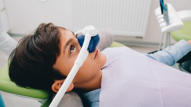 Young boy in dental chair wearing nitrous oxide sedation mask