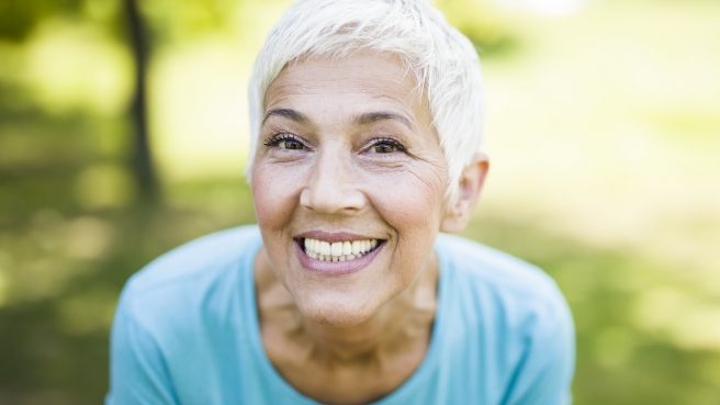 Senior woman grinning outdoors