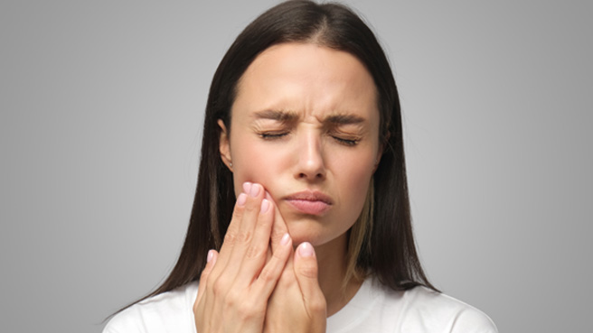 a woman holding her mouth in pain