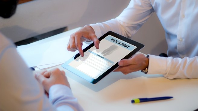 Two people looking at dental insurance information on tablet