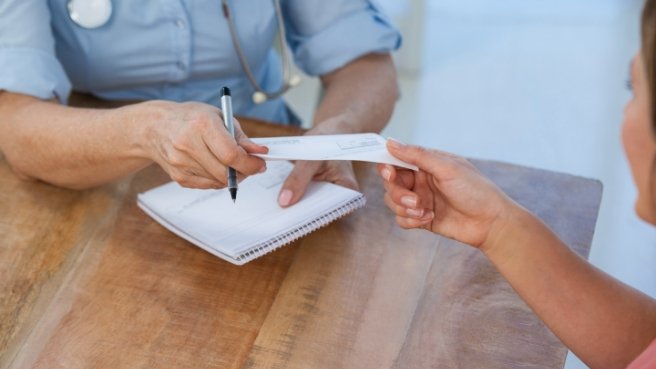 Woman handing a check to a dental professional