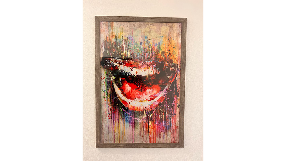 Painting on wall featuring smiling lips and multicolored paint splatters