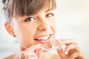 Woman placing Invisalign tray