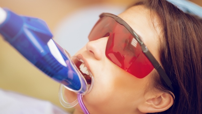 Young girl in dental chair with fluoride trays over her teeth