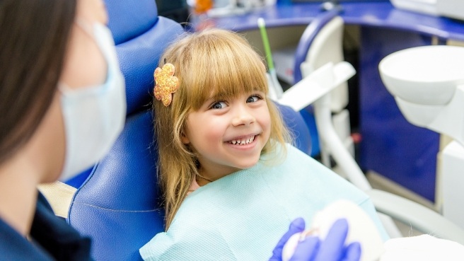 Smiling young girl in dental chair