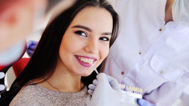 Woman smiling while talking to dentist about veneers