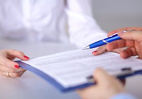 hands handing over a clipboard with forms on it 