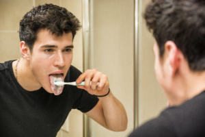 man brushing tongue