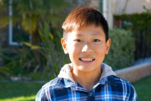 young teen wearing braces and standing outside