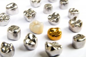 several metal crowns sitting around a ceramic crown