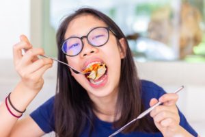 a child with braces eating pasta for lunch