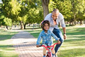 a child learning how to ride a bike with their parent