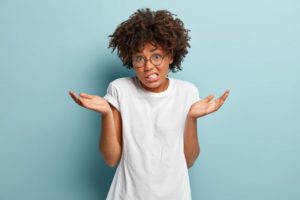 a person trying to make a decision between getting a dental bridge and a partial denture