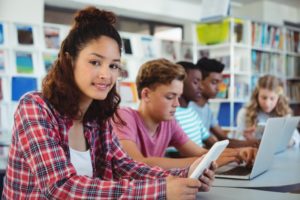 a teen sitting in their high school library with friends