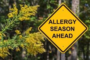 a street sign that says "allergy season ahead"