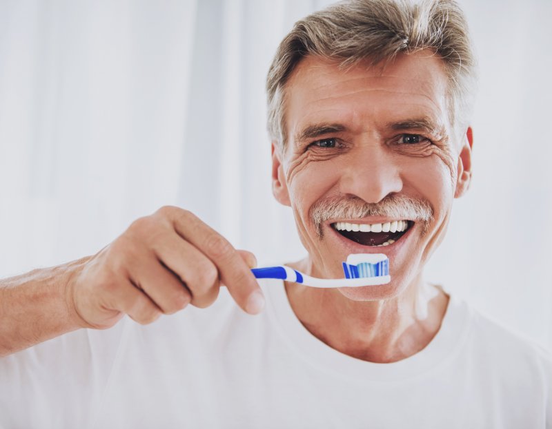 Man about to brush his dentures