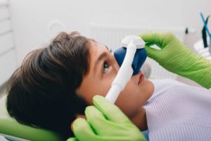 a child with a nose mask being placed on their face to administer nitrous oxide