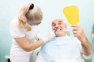 mature man in dental chair with mirror