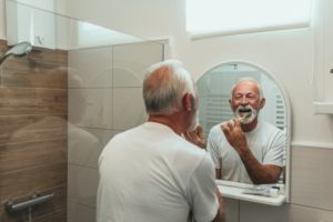 a person smiling and brushing their teeth