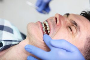 a mature man getting his braces adjusted
