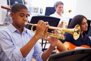 a teen playing trumpet in band class