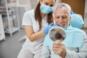 a dentist showing a patient his new smile after getting dental implants
