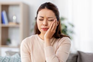 a person with a toothache holding their mouth