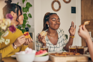 three women eating pizza together