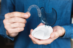 a person holding Invisalign aligners
